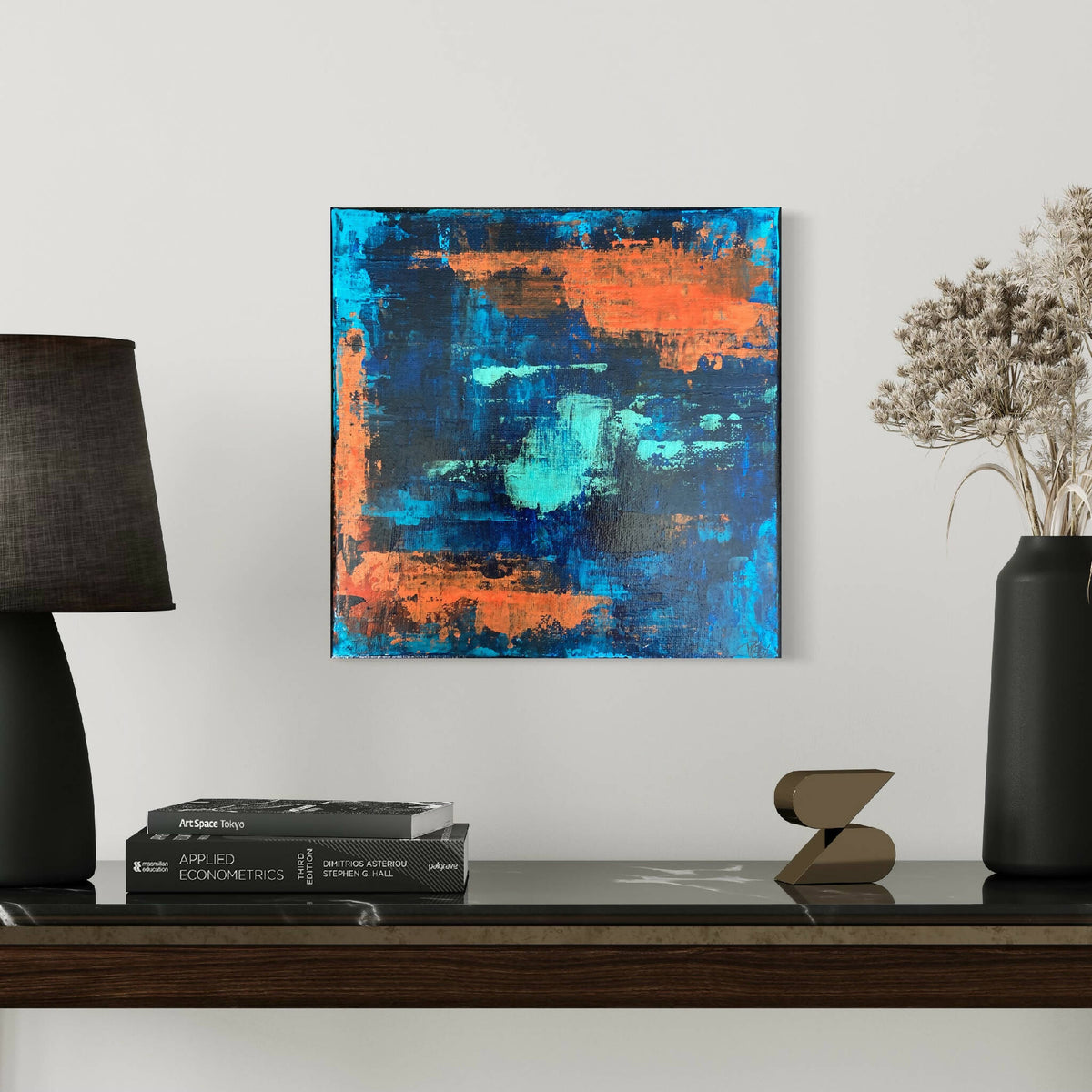 Tableau abstrait encadré, composition carrée bleu et orange, textures de peinture.