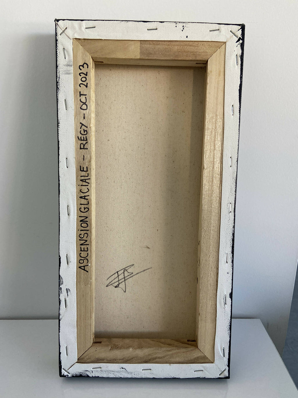Cadre au dos du tableau, inscription verticale « ASCENSION GLACIALE » sur fond clair.