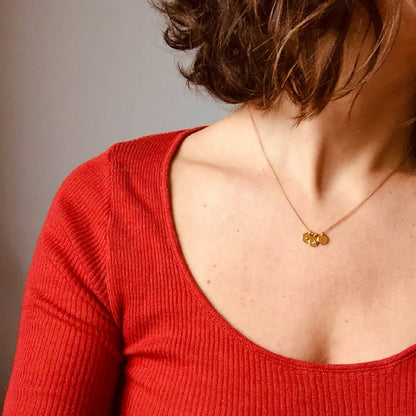 Collier doré à pendentif composé de trois médaillons ronds, porté au cou