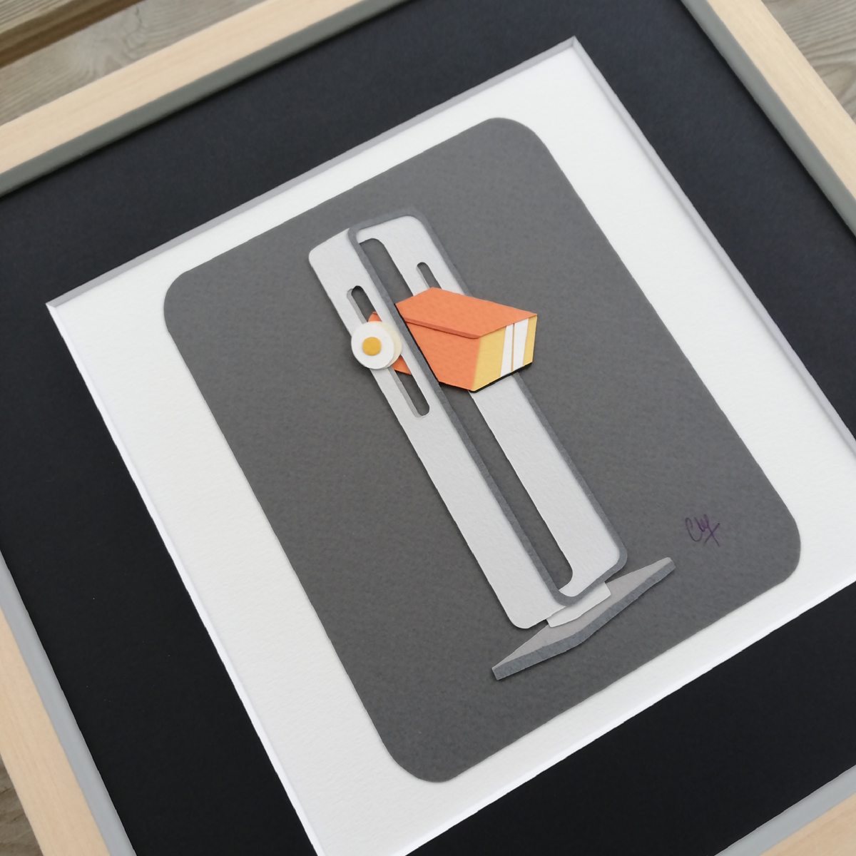 Lampe à poser décorative grise avec abat-jour orange, vue de face dans un cadre