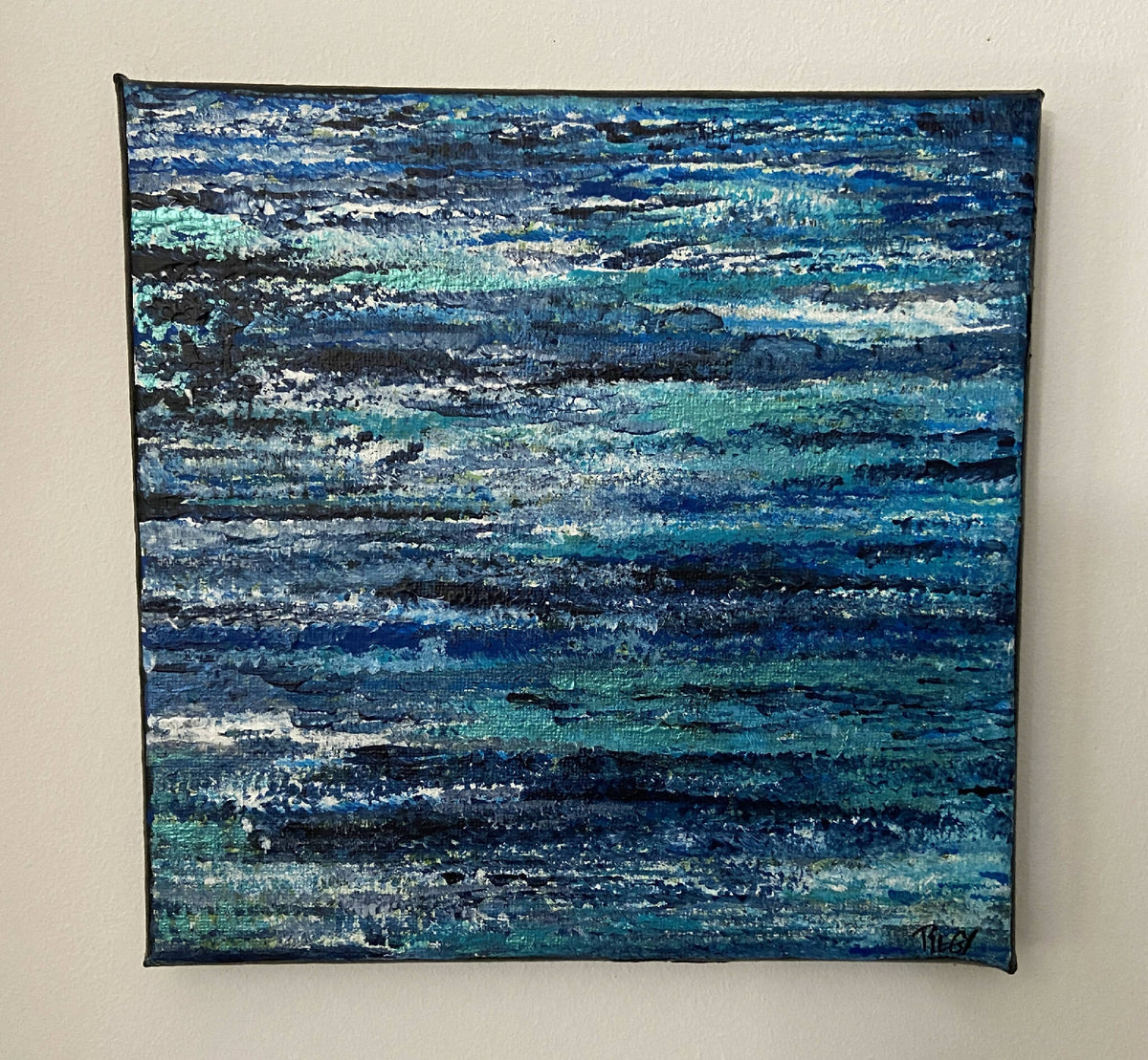 Tableau peinture abstraite sur toile, bleu nuit avec touches turquoise et blanches.